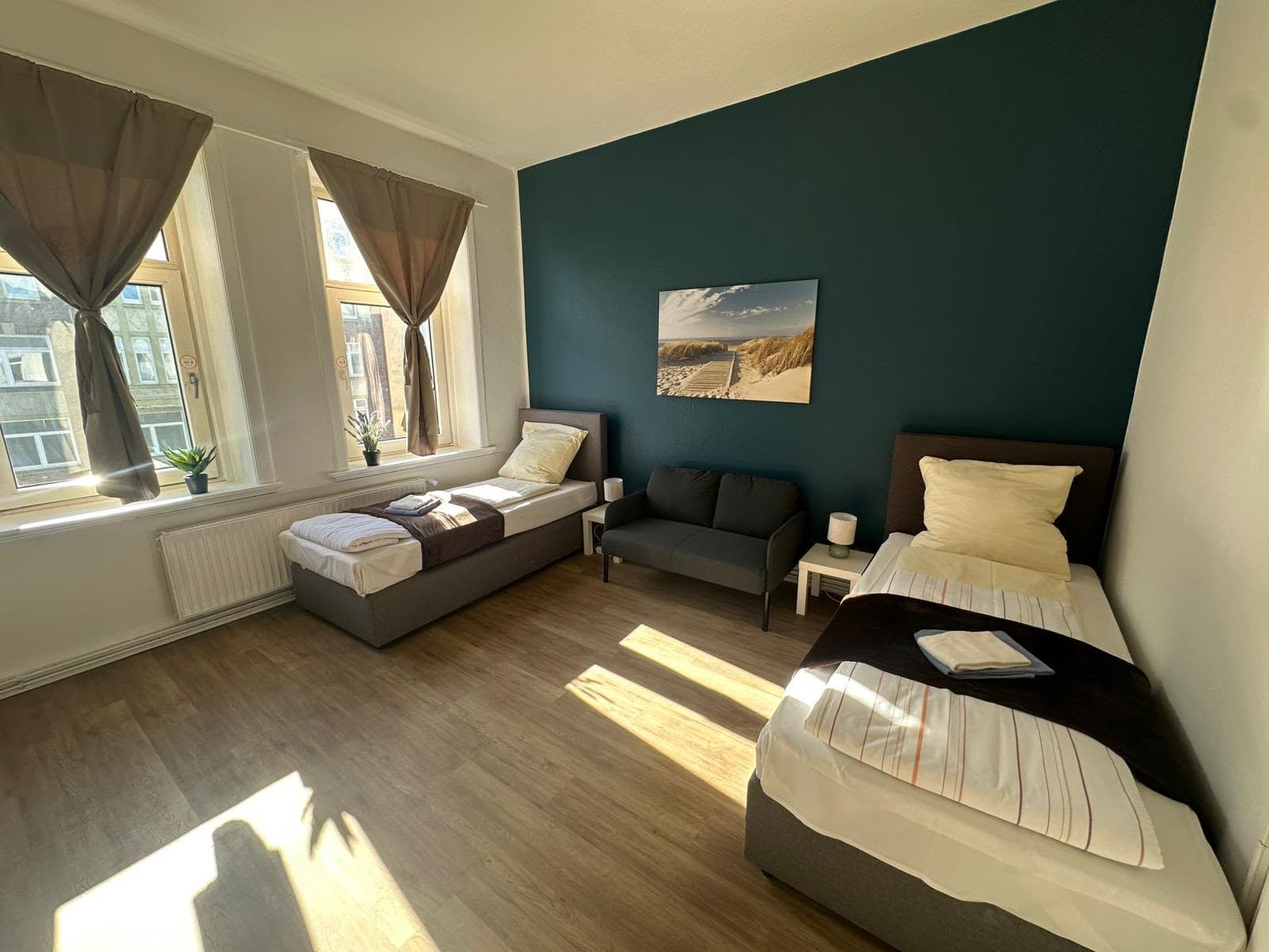 Helles Apartment mit zwei Einzelbetten, Sitzecke und großen Fenstern